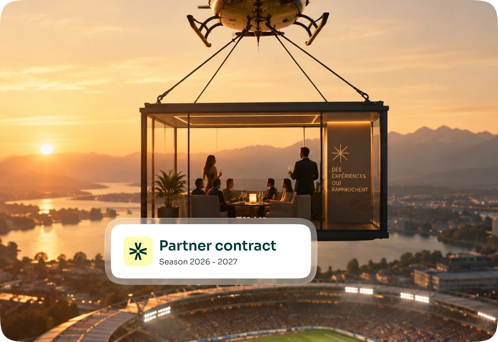 Ein an einem Hubschrauber hängender Salon über einem Stadion bei Sonnenuntergang, dazu das Schild eines Partnervertrags für die Saison 2026-2027